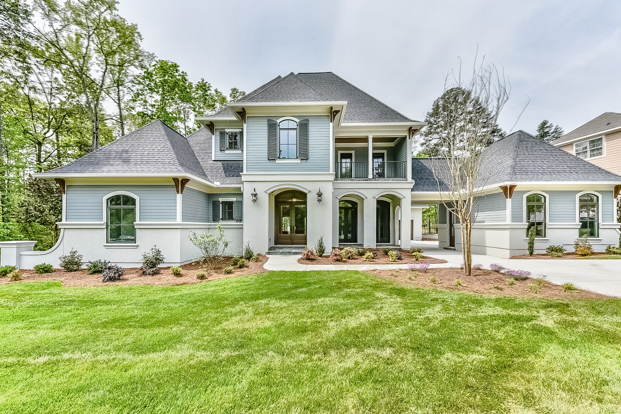 Custom Plattner home with a landscaped front lawn